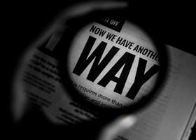 Home Black and white close-up of newspaper text magnified through a lens, emphasizing the word